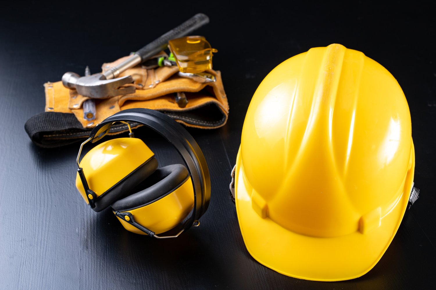 Helmet and accessories for construction workers. Accessories needed for work on the construction site. Dark background.